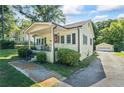 Quaint yellow home with a lovely front porch, a detached garage, and a paved driveway at 954 Bryant Sw St, Conyers, GA 30012