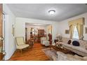 Sunlit living room with hardwood floors, a decorative rug, and a view into the dining area at 954 Bryant Sw St, Conyers, GA 30012