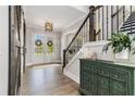 Elegant foyer featuring wood floors, a staircase with iron railings, and a decorative cabinet at 1865 Henley Way, Alpharetta, GA 30009