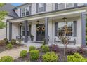 Inviting covered porch with decorative wreaths, stylish seating, and lush landscaping at 1865 Henley Way, Alpharetta, GA 30009