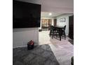 A view of the living room with a shaggy rug, TV, and an adjacent dining area at 170 Beatrice St, Dallas, GA 30157