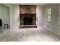Bright living room with stone fireplace and light woodgrain flooring at 170 Beatrice St, Dallas, GA 30157