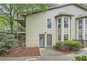 A townhome showing its siding and front entryway with a garden and trees surrounding the property at 2901 Lenox Rd # 702, Atlanta, GA 30324