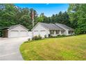 Ranch-style home with detached garage, ample parking, and well-maintained landscaping at 4274 Timber Trace Road, Loganville, GA 30052