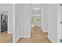 Bright hallway features hardwood floors, white trim and leads to a view of a sunlit room at 1897 Alcovy Trace Way Way, Lawrenceville, GA 30045