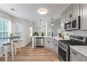 Modern kitchen with stainless steel appliances, gray cabinets, and hardwood floors at 2701 Windsor Nw Ct, Kennesaw, GA 30144