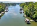 Aerial view of the lake, highlighting numerous docks and boat houses, surrounded by lush greenery at 2825 Lake Ct, Cumming, GA 30041