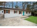 Charming ranch home with a turquoise door, a long driveway, and manicured lawn at 3893 Bonnie Se Ln, Atlanta, GA 30354