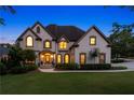 Charming two-story home with beautiful front lawn and warm, inviting exterior lighting at dusk at 100 Pine Mist Cir, Alpharetta, GA 30022