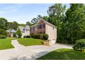 Lovely home with a well-kept lawn, driveway, and complemented by mature trees, providing a sense of tranquility and privacy at 1019 Legacy Walk, Woodstock, GA 30189