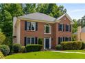Inviting brick home featuring lush landscaping, a manicured lawn, and classic design elements, creating a warm and welcoming atmosphere at 1019 Legacy Walk, Woodstock, GA 30189