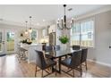 Stylish dining room with modern chandelier, light-filled windows, and an adjacent kitchen with breakfast bar at 683 Terry Se St, Atlanta, GA 30315