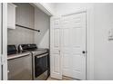 Modern laundry room with stainless steel appliances and stylish wallpaper at 6788 Oakhurst Court Ct, Douglasville, GA 30134