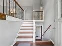 View of the home's entryway with wood and white stairs and natural light at 185 Hickory View Dr, Lawrenceville, GA 30046