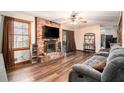 Inviting living room with a brick fireplace, hardwood floors, and a sliding glass door to a deck at 5843 Foxfield Trl, Rex, GA 30273