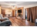 Cozy living room with hardwood floors, brick fireplace, and natural light offers a warm and inviting atmosphere at 5843 Foxfield Trl, Rex, GA 30273