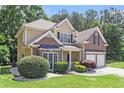 Traditional two-story home with brick and siding, featuring a well-maintained lawn and two-car garage at 1611 Hillside Bend Xing, Lawrenceville, GA 30043
