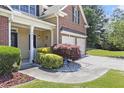Inviting front of house with manicured landscaping, columned porch and attached two-car garage at 1611 Hillside Bend Xing, Lawrenceville, GA 30043