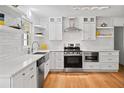Modern kitchen featuring white cabinets, stainless steel appliances, subway tile backsplash, and hardwood floors at 3332 Saint John Dr, East Point, GA 30344