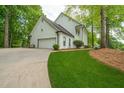 Exterior view of the white house featuring an attached garage and manicured lawn at 410 Glenmont Ct, Atlanta, GA 30350
