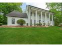 Beautiful front exterior with white columns, black trim windows and a well-maintained lawn at 410 Glenmont Ct, Atlanta, GA 30350