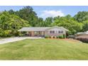 Well-maintained ranch home with a large, green front lawn and mature trees at 701 Rosedale Se Dr, Smyrna, GA 30082