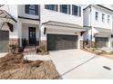 New construction townhome with a two-car garage, brick foundation, and landscaped yard at 816 Dodd S Trl # 172, Buford, GA 30518