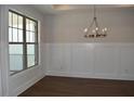 Dining room with dark hardwood floors, wainscoting, and a modern chandelier at 1619 Tielman Way, Snellville, GA 30078