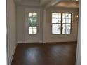 Bright room featuring hardwood floors, a glass-paneled door, and large windows at 1619 Tielman Way, Snellville, GA 30078