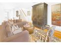 Comfortable living room with hardwood floors, brown couches, and a striking armoire and staircase at 195 Mystic Ct, Atlanta, GA 30342