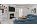 Bright living room features a fireplace, white marble floors, and a comfortable blue sofa set at 2983 Crosswycke Forest Dr, Brookhaven, GA 30319