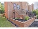 Brick townhouse featuring tidy landscaping with decorative rocks, black mulch, and lush green grass at 87 Davis Mill Ct, Lawrenceville, GA 30044