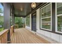 Inviting front porch with wood flooring, dark support columns, and a blue front door at 1158 Welch Sw St, Atlanta, GA 30310