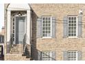 The exterior features a brick facade, classic windows with shutters, and an inviting front entry at 310 at 310 Rose Garden Ln, Alpharetta, GA 30009
