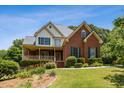Beautiful two-story home featuring a brick facade, covered porch, and manicured landscaping at 3175 Lake Seminole Pl, Buford, GA 30519