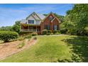 Two-story home with a brick facade, covered porch, and well-maintained landscaping on a sunny day at 3175 Lake Seminole Pl, Buford, GA 30519
