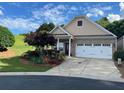 Charming home featuring a two-car garage, manicured garden, and covered porch at 407 Aerif Pl, Woodstock, GA 30188
