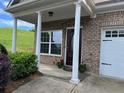 Inviting front entrance with brick facade, white columns, and well-maintained landscaping at 407 Aerif Place Pl, Woodstock, GA 30188