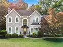 Charming two-story home featuring arched windows, a covered entrance, and mature landscaping at 1801 Summerview Ct, Woodstock, GA 30189