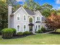 Two-story traditional home boasts mature landscaping, manicured lawn, and an inviting facade at 1801 Summerview Ct, Woodstock, GA 30189