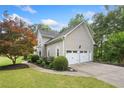 A two-story home displays a 3-car garage, meticulous landscaping, and a paved walkway at 1801 Summerview Ct, Woodstock, GA 30189