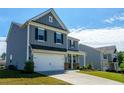 Two-story home with a two-car garage showcasing its front and side yard at 4420 Merrigold Way, Fairburn, GA 30213