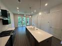 Modern kitchen with island, stainless appliances, pendant lights, and sliding doors opening to outdoor space at 962 Bibbs Circle Nw # 6, Atlanta, GA 30318