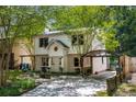 Charming two-story home with a brick foundation, a well-manicured lawn, carport, and mature trees at 1071 Standard Ne Dr, Brookhaven, GA 30319