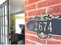 Close-up of house number 2674 on a brick wall next to a glimpse of the home's interior at 2674 Misty Rock Cv, Dacula, GA 30019