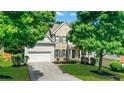 Home with mature landscaping, well-kept lawn, and a two-car garage at 3980 Suwanee Place Dr, Suwanee, GA 30024