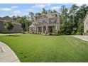 Beautiful home with a spacious lawn, mature trees, and a basketball hoop on the driveway at 4960 Norman Ct, Cumming, GA 30040