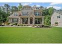 Attractive two-story home showcasing a lush lawn, stone details, and a welcoming entrance at 4960 Norman Ct, Cumming, GA 30040