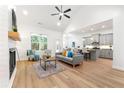 Bright and airy living room featuring a fireplace, vaulted ceiling, and seamless flow to the kitchen at 8544 Plumtree Dr, Riverdale, GA 30274