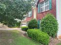 A classic brick home with green shutters and lush landscaping, offering curb appeal and charm at 1570 Twin Bridge Ln, Lawrenceville, GA 30043